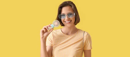 Eine Frau mit Sonnenbrille hält einen tragbaren Mini-Ventilator.