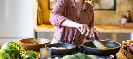Eine Frau steht in der Küche und kocht.